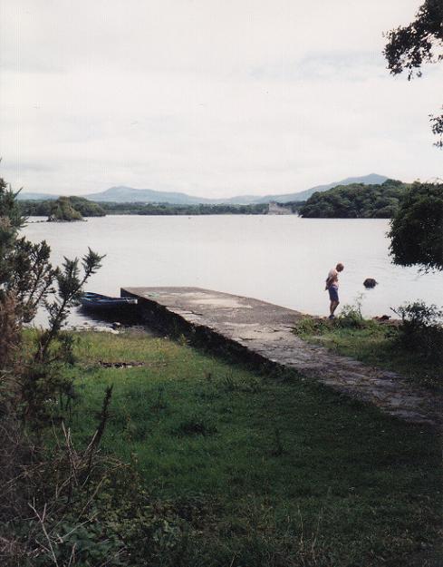 Our little rowboat is on the left of the pier; Ross Castle can be seen in the distance across the lake.